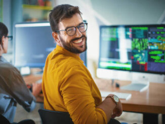 a male web developer looking back and smiling